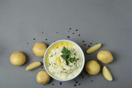 Bowl of mashed potatoes and ingredients on gray backgroundの写真素材