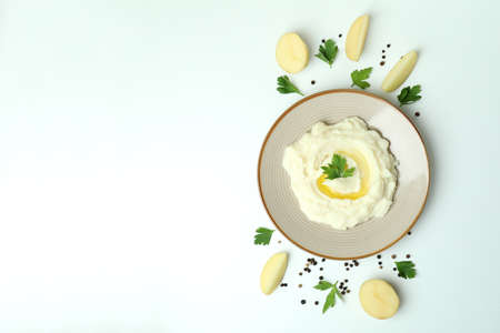 Plate of mashed potatoes and ingredients on white backgroundの写真素材