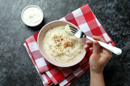 Concept of tasty eating with mashed potatoes on black smokey tableの写真素材