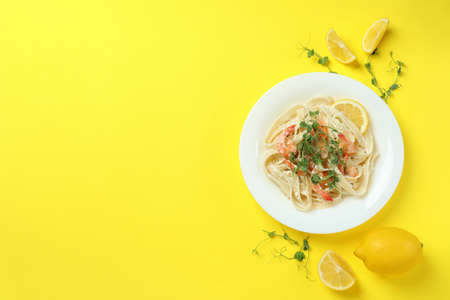 Plate of tasty shrimp pasta on yellow backgroundの写真素材
