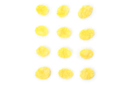 Dry uncooked corn flakes isolated on white background