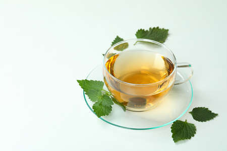 Cup of nettle tea and ingredients on white backgroundの写真素材