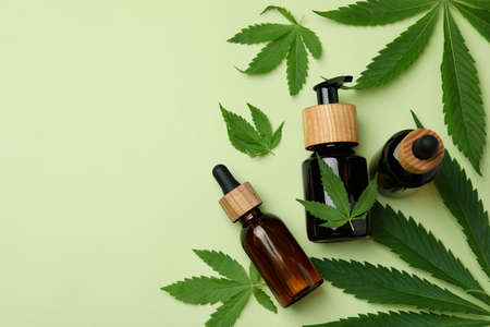 Bottles with cannabis oil and leaves on green backgroundの写真素材