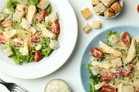 Concept of tasty eating with Caesar salad on white background