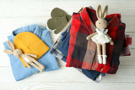 Donation concept with clothes on white wooden background