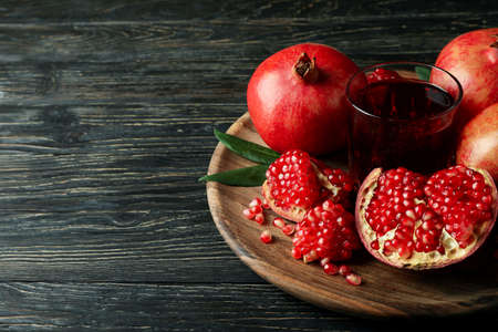 Board with pomegranate juice and ingredients on wooden tableの写真素材