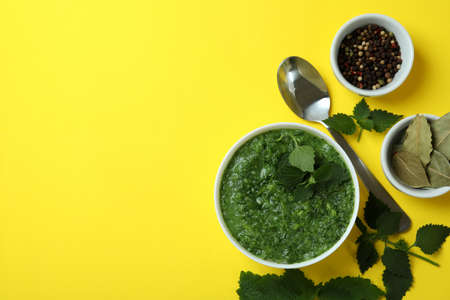 Concept of healthy food with nettle soup on yellow table