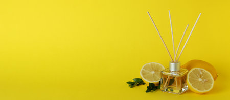 Diffuser, lemons and leaves on yellow backgroundの写真素材