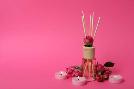 Diffuser, candles and roses on pink backgroundの写真素材