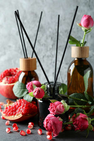Diffusers, flowers and pomegranate on dark wooden tableの写真素材