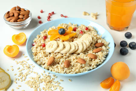 Bowl of oatmeal and ingredients on white backgroundの写真素材