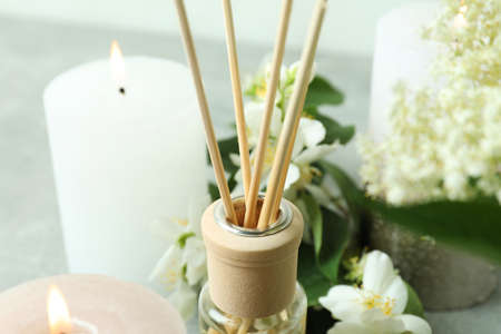 Aromatic concept with diffuser, flowers and candles close up