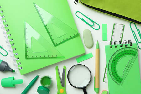 Different green stationery on white background, top view