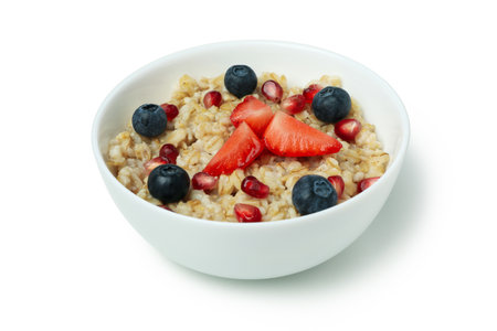 Bowl of oatmeal with tasty ingredients isolated on white backgroundの写真素材