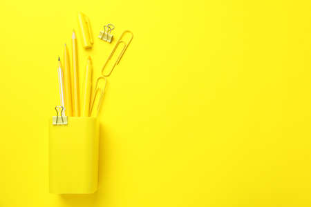 Holder with different stationery on yellow backgroundの写真素材