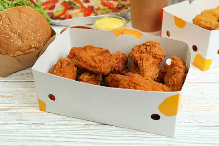 Concept of fast food on white wooden table
