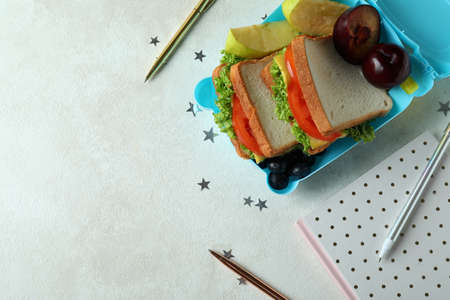 Workplace with lunch box on white textured tableの写真素材