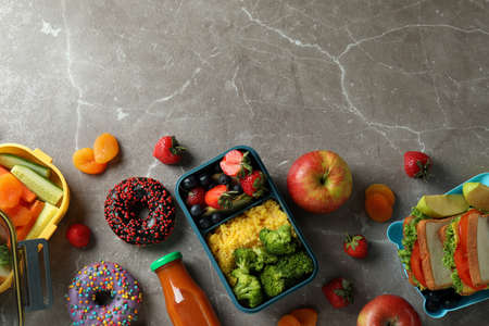 Lunch boxes with tasty food on gray textured table