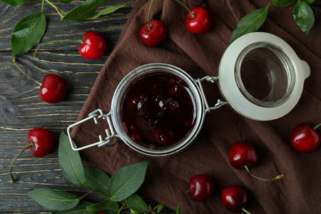 Cherry jam and ingredients on rustic wooden tableの写真素材