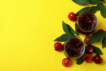Cherry jam and ingredients on yellow backgroundの写真素材