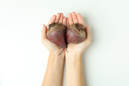 Female hands hold fresh beets on white backgroundの写真素材