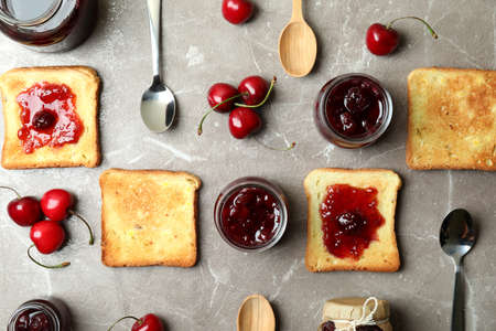 Cherry jam sandwiches and ingredients on gray textured backgroundの写真素材