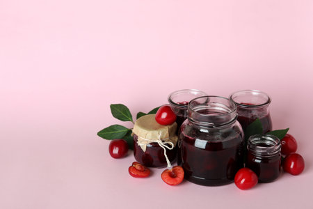 Cherry jam and ingredients on pink backgroundの写真素材
