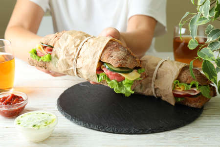 Concept of tasty eating with ciabatta sandwiches on white wooden table