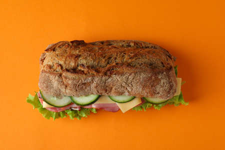 Sandwich of ciabatta bread on orange background