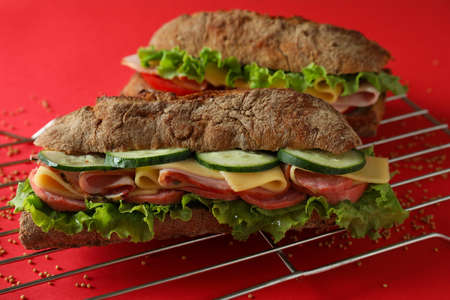 Baking rack with ciabatta sandwiches on red backgroundの写真素材