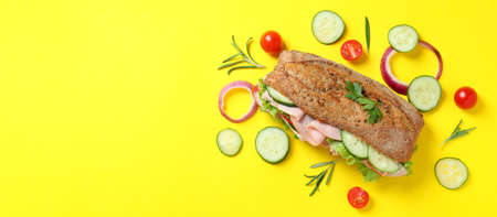 Ciabatta sandwich and ingredients on yellow backgroundの写真素材