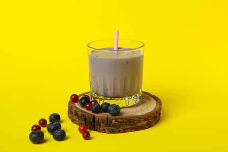 Fresh blueberry smoothie and ingredients on yellow backgroundの写真素材