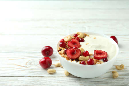 Concept of tasty breakfast with yogurt on wooden table