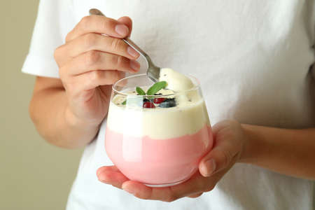 Young woman eats berry yogurt, close up