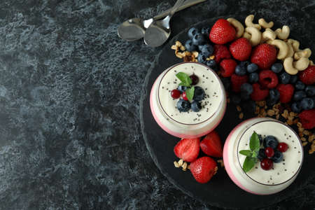 Concept of tasty breakfast with yogurt on black smokey table