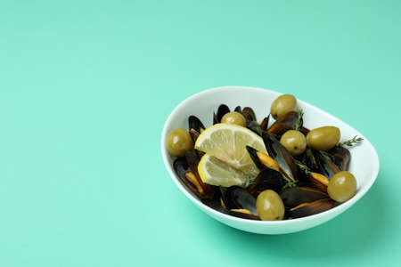 Bowl of mussels with spices on mint backgroundの写真素材