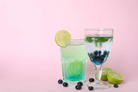 Glasses of fresh summer cocktails and ingredients on pink backgroundの写真素材