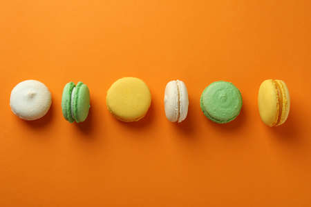 Concept of tasty dessert with macarons on orange backgroundの写真素材