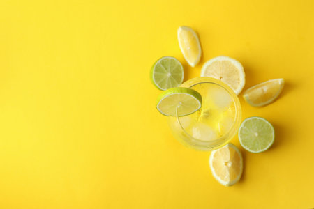 Glass of lemon cocktail and ingredients on yellow backgroundの写真素材