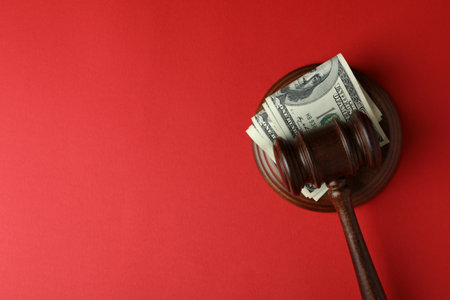 Judge gavel with dollars on red backgroundの写真素材
