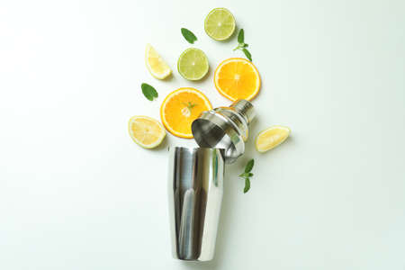 Shaker with citrus cocktail ingredients on white background
