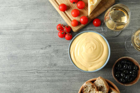 Concept of delicious food with fondue on gray textured table