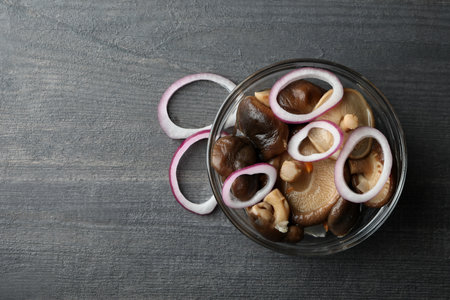 Bowl of marinated mushrooms on dark wooden tableの写真素材