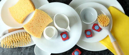Concept of Dishwashing detergent accessories on black smokey table