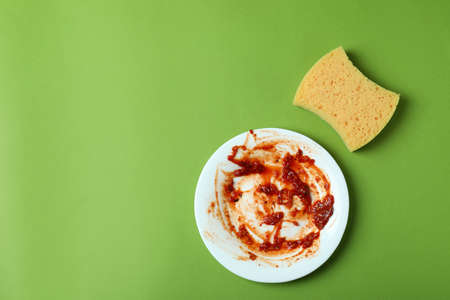 Concept of dirty dishes on green background
