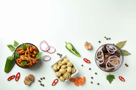 Bowls of marinated mushrooms on white background