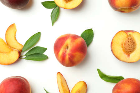 Ripe peach fruits with leaves on white backgroundの写真素材