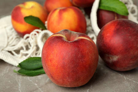 String bag with peach fruits on gray textured tableの写真素材