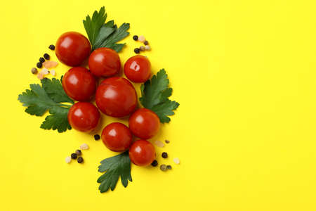 Pickled tomatoes and spices on yellow backgroundの写真素材
