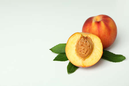 Ripe peach fruits with leaves on white backgroundの写真素材